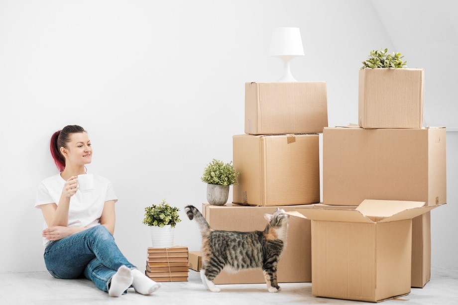 women holding mug in her hand with boxes around her 