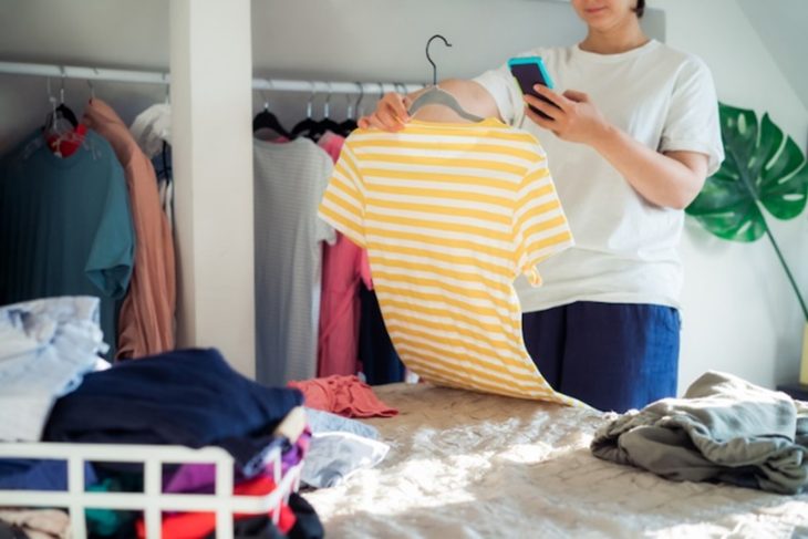 Uni student looking through clothes to move