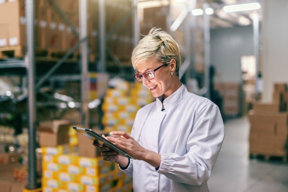 woman checking inventory on a tablet in a warehouse