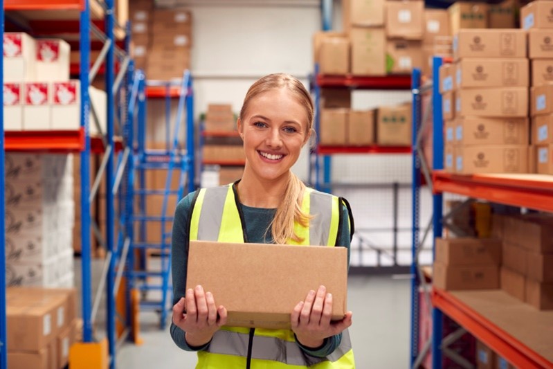 woman holding a box in a warehouse
