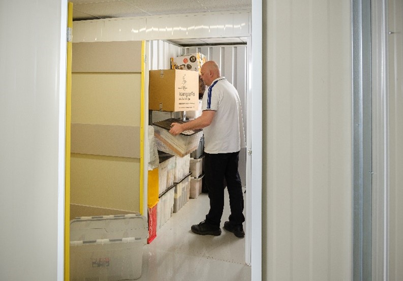 man packing storage unit with boxes