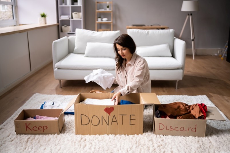 woman sorting through old items to donate, keep, and discard