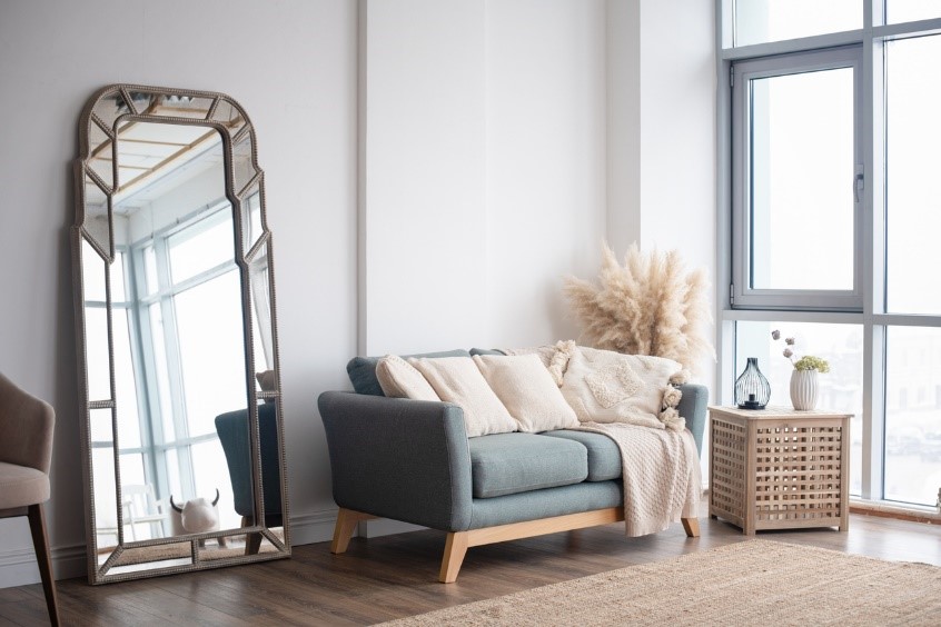 living room with grey couch and large freestanding mirror